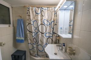 a bathroom with a sink and a shower curtain at Marina Apartment in Piraeus
