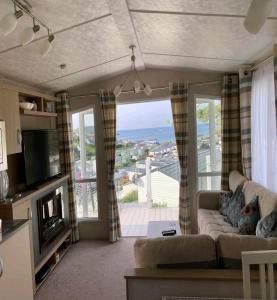 Ocean Pearl , 20 Circular , Challaborough Bay في Bigbury: غرفة معيشة مع أريكة وإطلالة على المحيط