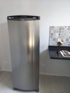 einem Kühlschrank aus Edelstahl neben einer Wand in der Unterkunft Kitnet 1 - próximo ao centro de Jacareí in Jacareí
