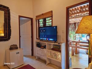 a living room with a flat screen tv on a stand at Mini Casa com Jacuzzi e Piscina in Trancoso