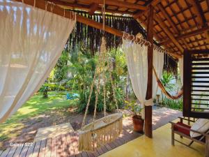 a porch with a hammock and a swing at Mini Casa com Jacuzzi e Piscina in Trancoso