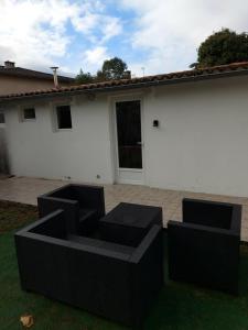 eine Terrasse mit schwarzen Möbeln vor einem Haus in der Unterkunft studio au calme wifi 600m centre ville in Castres