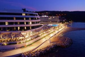 a view of a building with a beach at night at Grand Hotel View in Postira