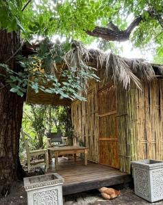 una terraza de madera con un banco y un árbol en Sandton Safari Camp, en Johannesburgo