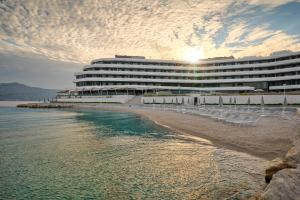 a hotel on the beach with chairs and the ocean at Grand Hotel View in Postira