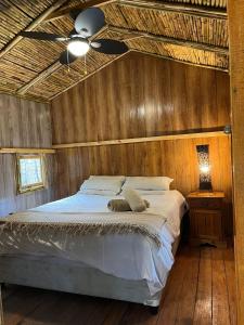 sypialnia z łóżkiem i wentylatorem sufitowym w obiekcie Sandton Safari Camp w mieście Johannesburg