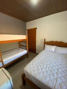 - une chambre avec un lit et des lits superposés dans l'établissement Sítio das Araras, à Jaboticatubas