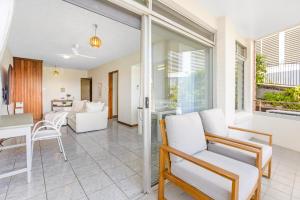 ein Wohnzimmer mit weißen Stühlen und einem Tisch in der Unterkunft Cleveland Terrace 1-23A in Townsville