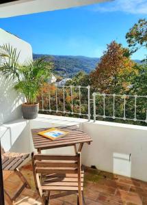 a table and a chair on a balcony at Casa Malva - Traditional townhouse apartment in Monchique