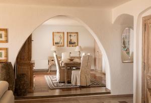 une voûte dans une salle à manger avec une table et des chaises dans l'établissement Romazzino, A Belmond Hotel, Costa Smeralda, à Porto Cervo