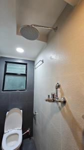 uma casa de banho com um WC e uma janela em Badri Homes em Pātan