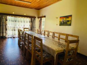 ein Esszimmer mit einem langen Tisch und Stühlen in der Unterkunft Lisa place milimani in Kitale