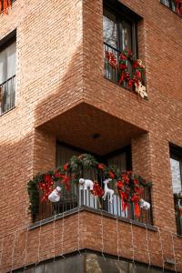 a brick building with two windows with christmas wreaths at 26Bricks Luxury Suites in Oradea