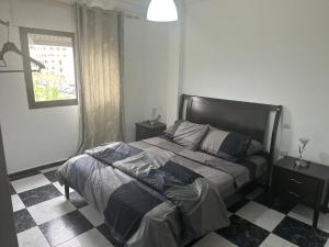 a bedroom with a bed and a checkered floor at Casa lux in Tetouan