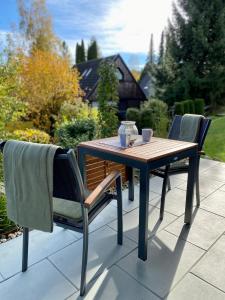 a wooden table and two chairs on a patio at Allgäu Neschd in Oberreute