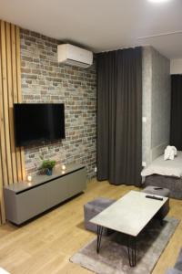 uma sala de estar com televisão numa parede de tijolos em Luxury Apartment Skopje em Skopje