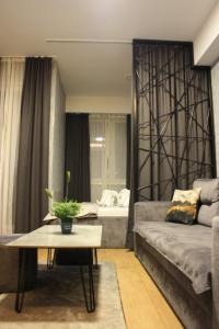 uma sala de estar com um sofá e uma mesa em Luxury Apartment Skopje em Skopje