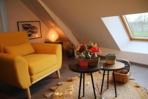 a living room with a yellow couch and a table at La Catiniere in Arnage