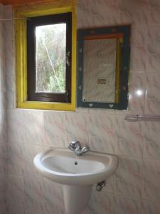 a bathroom with a sink and a window at Prakriti neerh in Jyoti Gaon