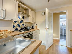 una cucina con lavandino e piano cottura forno superiore di 2 bed in Sutton-on-Sea 80703 a Sutton on Sea