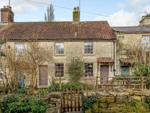 una vieja casa de piedra con una valla delante de ella en 2 Bed in Bath 81298 en Wingfield