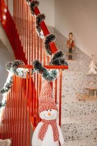 un muñeco de nieve en una escalera con adornos navideños en 26Bricks Luxury Suites, en Oradea