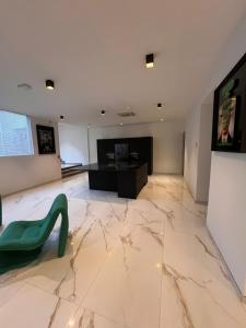 uma sala de estar com piso em mármore e uma cadeira verde em Appartement Loft haut standing em Douai