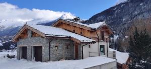 a house in the snow with a mountain in the background at l'appartement montagnard d'Estelle 4-6 personnes in Lanslebourg-Mont-Cenis