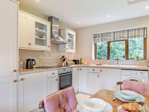 a kitchen with white cabinets and a wooden table at 1 bed in Bampton LIMKC in Bampton