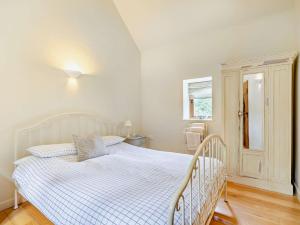 a bedroom with a white bed and a window at 1 bed in Bampton LIMKC in Bampton