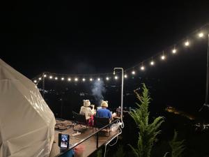 閣考島的住宿－Peace Zone เขาค้อ，两人在晚上坐在桌子旁的灯光下