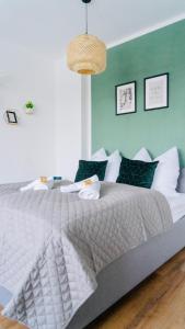 ein Schlafzimmer mit einem weißen Bett und einer grünen Wand in der Unterkunft SH-Apartment Petra *zentral & stilvoll* in Erfurt
