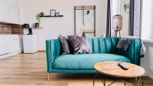 ein grünes Sofa im Wohnzimmer mit einem Tisch in der Unterkunft SH-Apartment Petra *zentral & stilvoll* in Erfurt