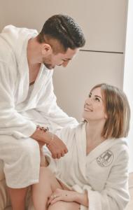 a man and a woman in a bath robe at B&B Il Vico del Greco in Le Castella