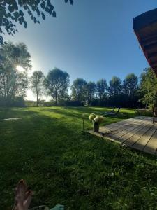 a person laying on the grass next to a wooden deck at Home Bij Zee in Koudekerke +27 photos