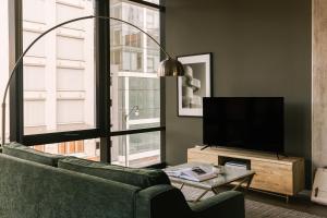 a living room with a green couch and a large window at Sonder South Wabash in Chicago