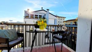 Un balcón con una mesa con un jarrón de flores. en Appartamento vicino al centro Adigeo e fiera en Verona