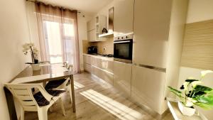 cocina con encimera, mesa y sillas en Appartamento vicino al centro Adigeo e fiera en Verona