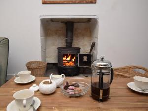 a wooden table with a stove in a fireplace at 3 Bed in North Uist 77239 in Sollas
