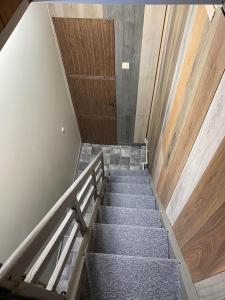 a staircase in a building with a wooden door at Butas S. Daukanto gatvėje in Telšiai