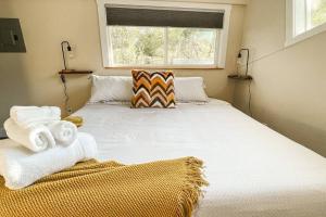 a bedroom with a large bed with towels on it at Stylish remodeled studio near IvyWild/Downtown in Colorado Springs