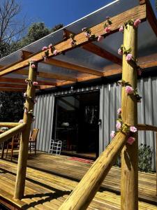 a wooden pergola on a wooden deck at Chalé Container do Beijo in Campos do Jordão
