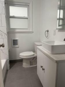 BloomfieldにあるSUITE DREAMs BLOOMFIELD 34の白いバスルーム(トイレ、シンク付)