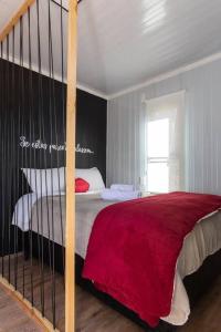 a bedroom with a bed with a red blanket at Chalé Container do Beijo in Campos do Jordão