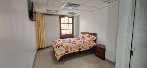 a bedroom with a bed and a window at HOTEL TICLIO in Cajamarca