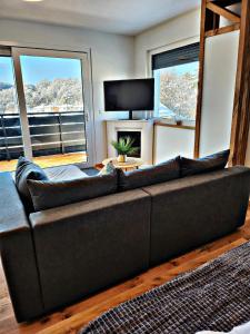 a living room with a couch and a large window at Lions Place Premium Apartments EXECUTIVE Luxus PENTHOUSE inklusive SPA in Heidenheim an der Brenz