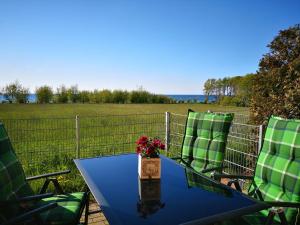a table with two chairs and a table with flowers at Hof am Meer "Seeadler" in Meschendorf