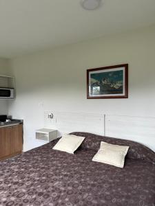 1 dormitorio con 1 cama grande y 2 almohadas en Fitz Roy Hostería de Montaña - El Chaltén en El Chaltén