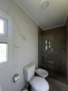 a white bathroom with a toilet and a shower at Fitz Roy Hoster&iacute;a de Monta&ntilde;a - El Chalt&eacute;n in El Chalten