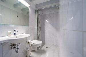 ein weißes Bad mit einem WC und einem Waschbecken in der Unterkunft Huus Lüttenblick Single Wohnung Kajüte in Südstrand